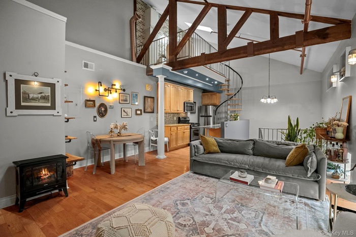 Welcome to 88 Broadway Unit PH4, a stunning penthouse where exposed beams, vaulted ceilings, and copper accents create the perfect fusion of SoHo loft