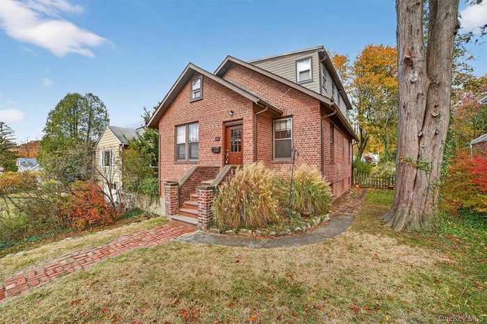 View of front of property with brick siding and stairs