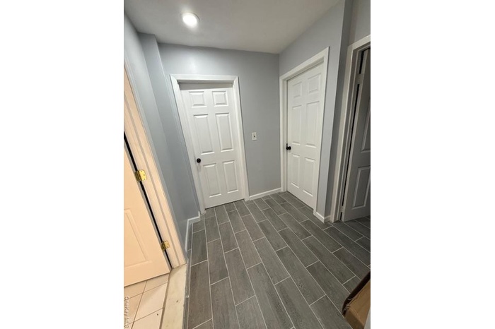 Corridor with wood finish floors and baseboards