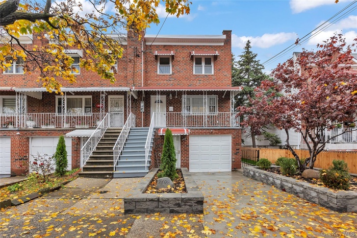 View of front of house with brick siding, stairway, and driveway