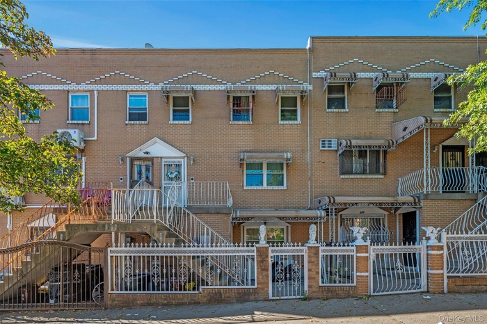 View of front facade featuring a gate, a fenced front yard, and brick siding