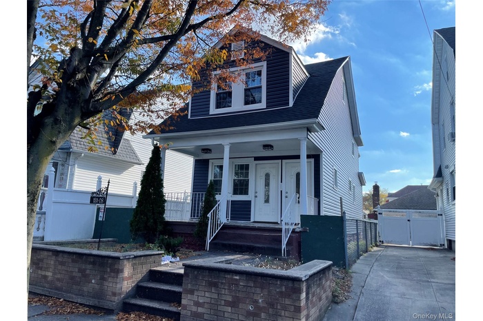 View of front of home featuring a porch, roof with shingles, and a gate