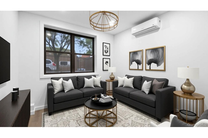 Living area with a wall mounted AC and light wood-type flooring