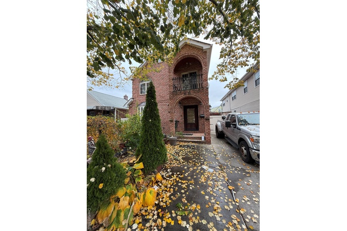 View of front of home with brick siding and a balcony