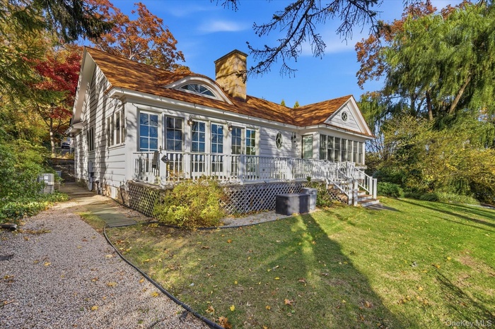 Rear view of house featuring a chimney, deck and a yard