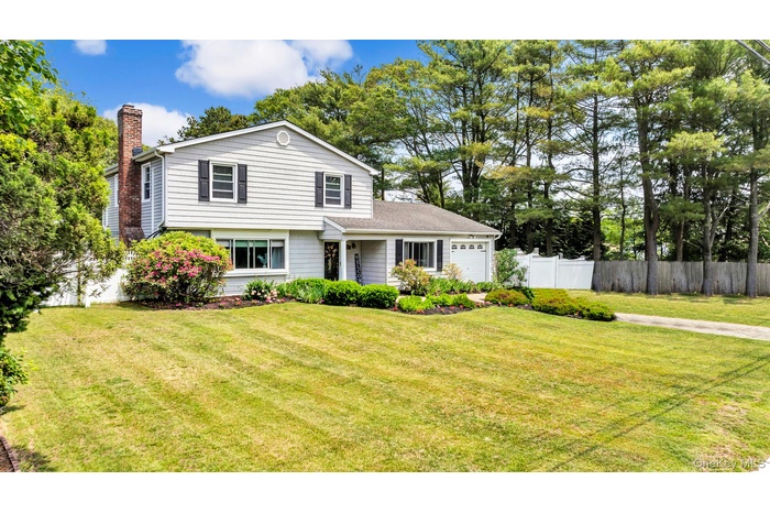 View of front of home with a chimney and a garage