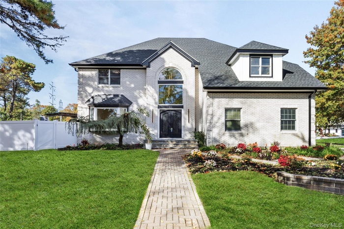 View of front of property with roof with shingles and brick siding