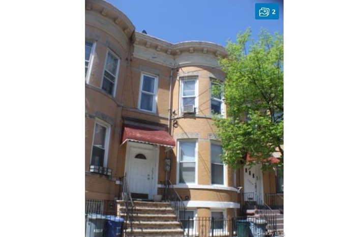 Italianate house featuring brick siding and a fenced front yard