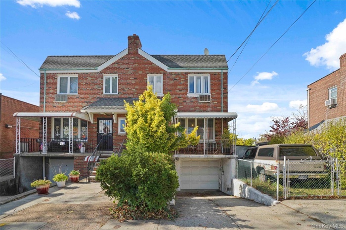Traditional home featuring brick siding, a chimney, concrete driveway, and a garage