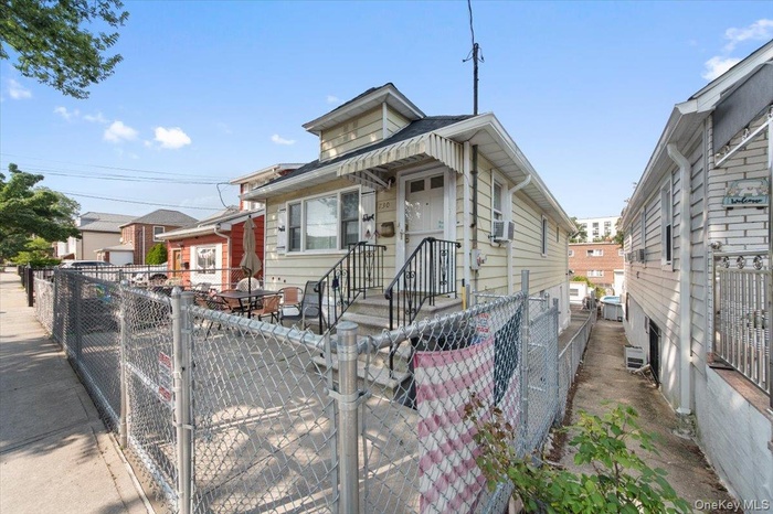 Shotgun-style home with a fenced front yard and a gate