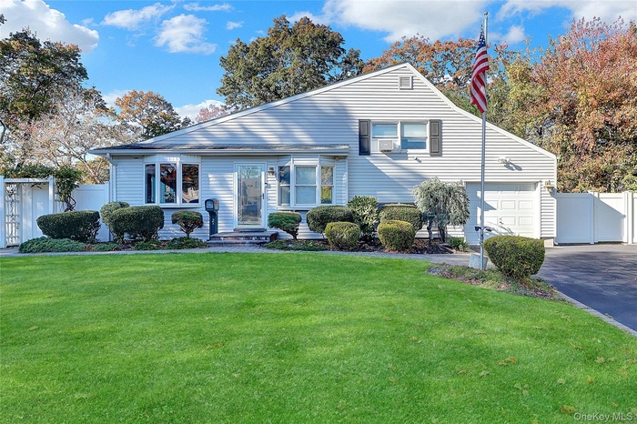 View of front of home featuring driveway and a gate