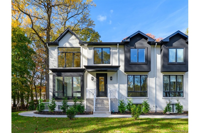 View of front of property with stucco siding and a front yard