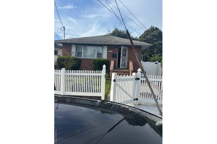 View of front facade with brick siding, a gate, and a fenced front yard