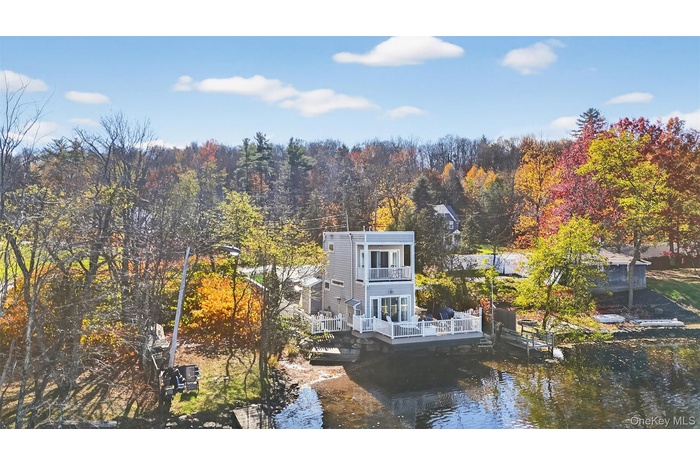 View from above of property with a forest and a large body of water