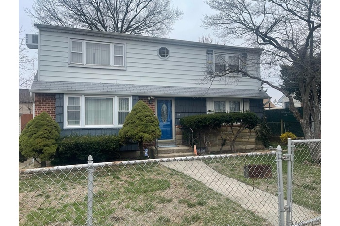 Traditional-style house featuring a fenced front yard and a gate