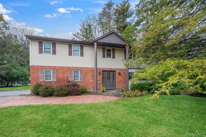 View of front of home with a front yard and brick siding