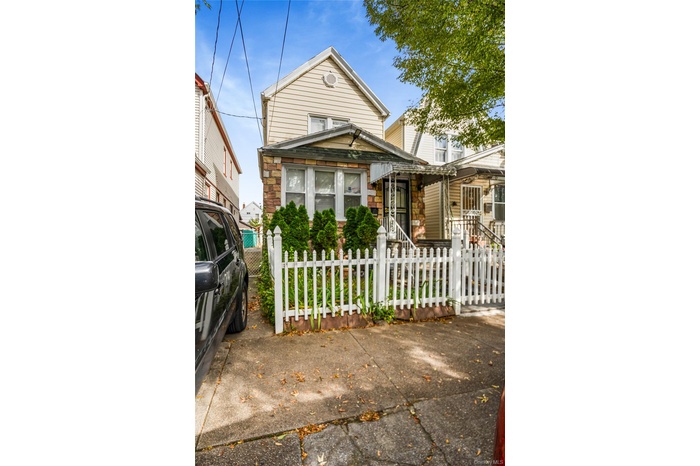 View of front of property with a fenced front yard and stone siding