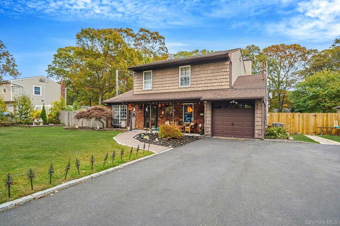 Traditional-style home featuring driveway, a porch, a chimney, and a shingled roof