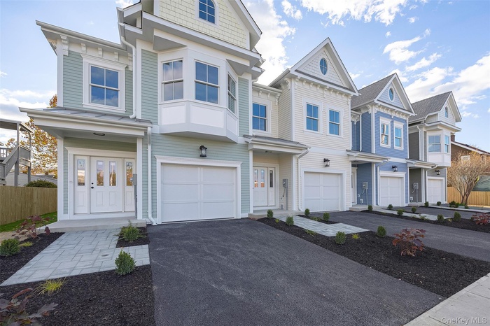 View of front of property featuring driveway, an attached garage, and a residential view