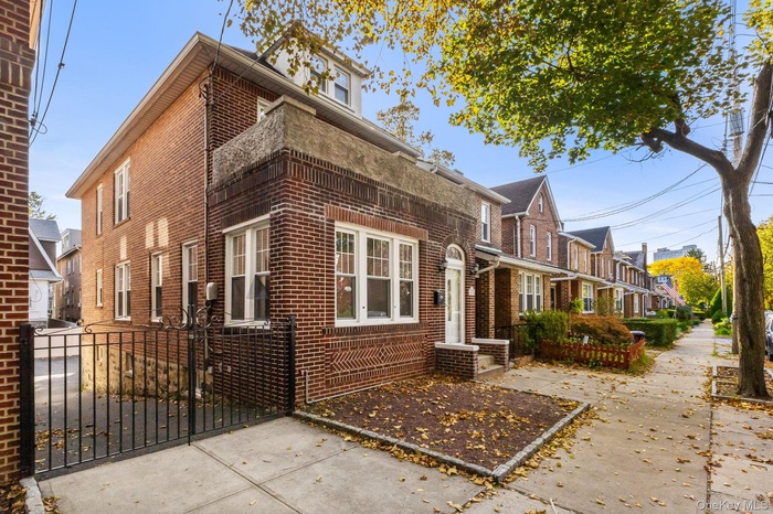View of home's exterior featuring brick siding, a gate, and a residential view
