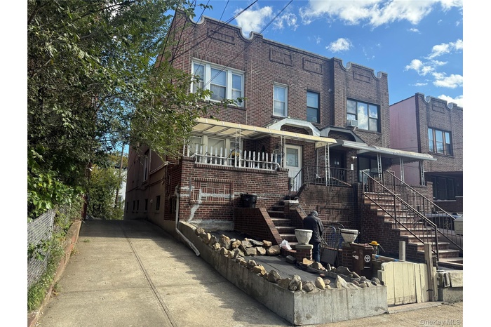 Traditional-style home featuring brick siding, stairs, and a porch