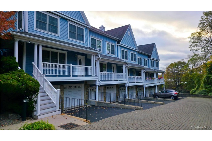View of property featuring stairs, an attached garage, driveway, and a residential view
