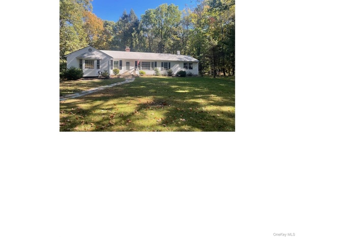 Ranch-style house featuring a front yard and a chimney