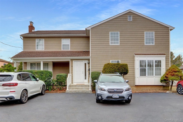 View of front of property featuring a chimney and a shingled roof