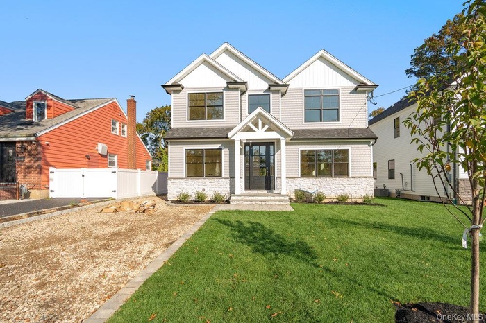 Craftsman-style home with stone siding, a gate, and board and batten siding