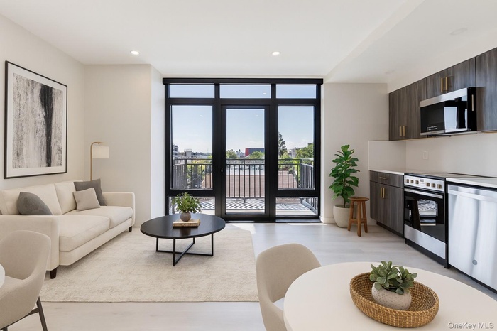 Living room with a wall of windows, light wood-style flooring, and recessed lighting