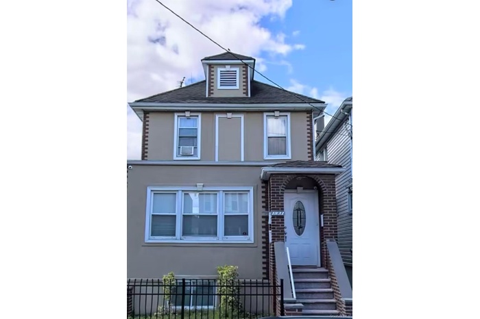 View of front of property with a fenced front yard, stucco siding, roof with shingles, and brick siding