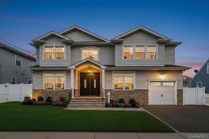 Craftsman house featuring a gate, stone siding, driveway, and a garage