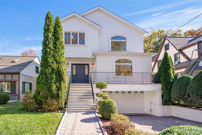 View of front of house featuring stairs, stucco siding, decorative driveway, and an attached garage