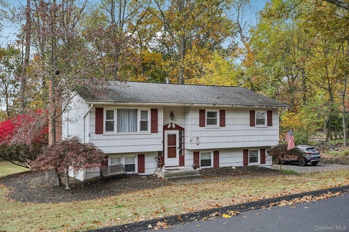Split foyer home featuring a shingled roof