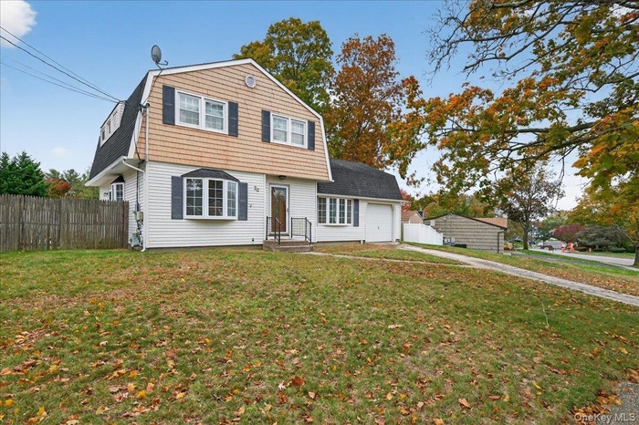 Dutch colonial featuring a gambrel roof, an attached garage, and driveway
