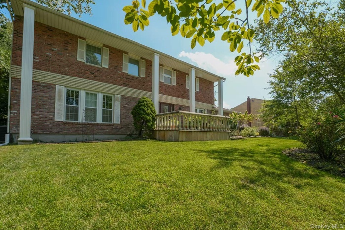 Front of property featuring brick siding, a yard, and covered porch
