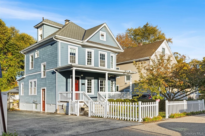 View of front of home featuring covered porch, a fenced front yard and roof with shingles