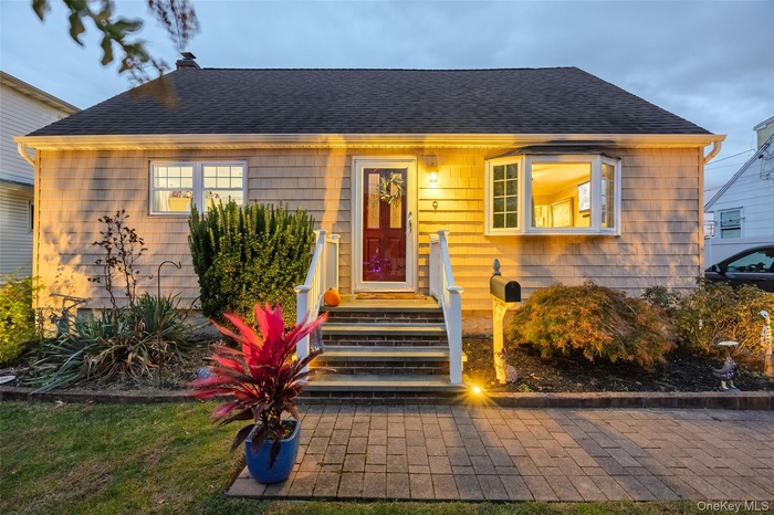 Bungalow-style house with roof with shingles, a chimney, and a patio area