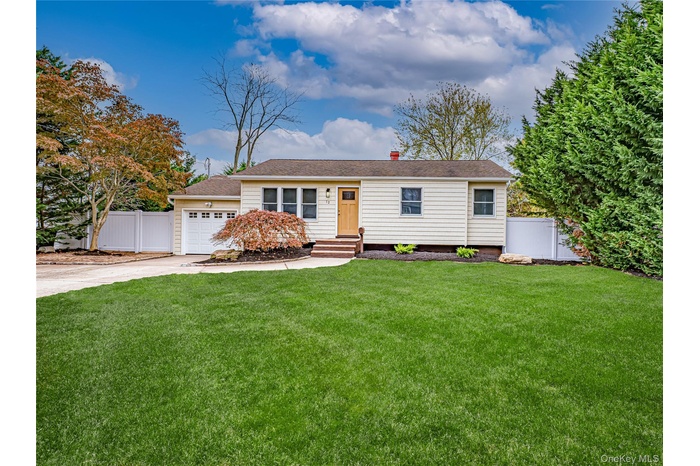Single story home with concrete driveway, a chimney, a shingled roof, and a gate