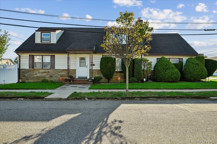View of front of home featuring stone siding and a shingled roof