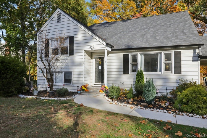View of front of property with a front yard and a shingled roof