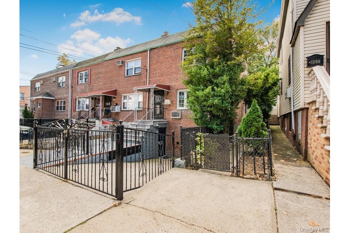 View of front of home with a gate, brick siding, and a fenced front yard