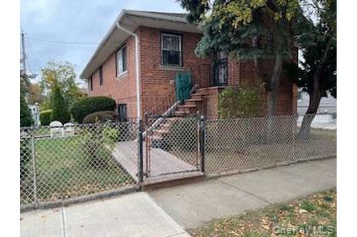 Bungalow-style home with a gate, a fenced front yard, and brick siding