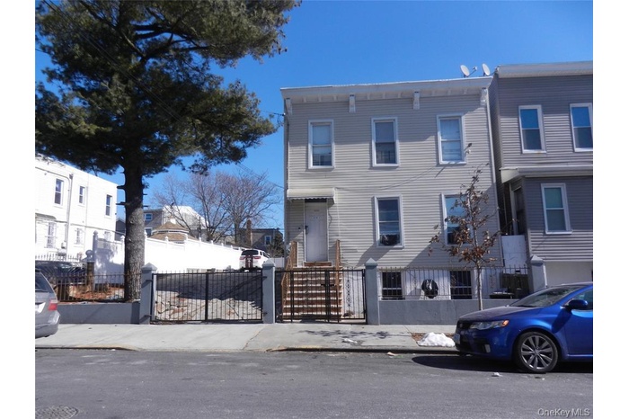 View of front of property featuring a fenced front yard and a gate