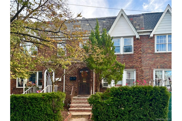 View of front of house with roof with shingles and brick siding