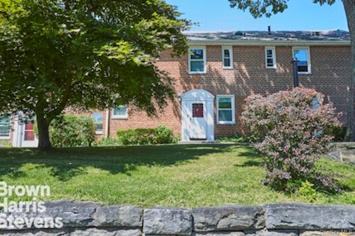 View of front of house with brick siding and a front yard