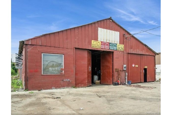 View of building exterior featuring a garage and an outbuilding