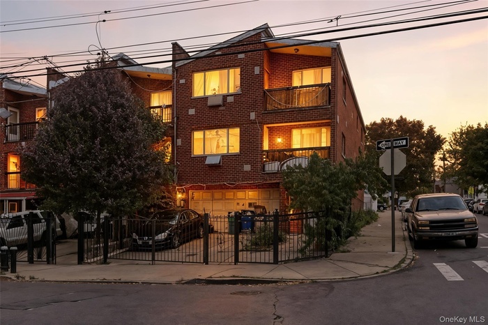 View of front of home with brick siding, a balcony, and driveway