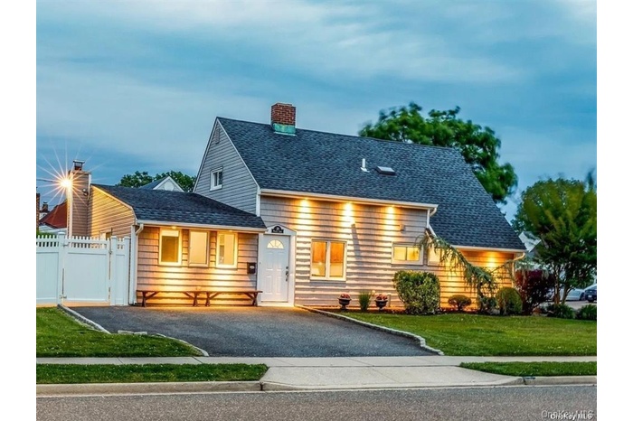 View of front of home featuring roof with shingles and a chimney