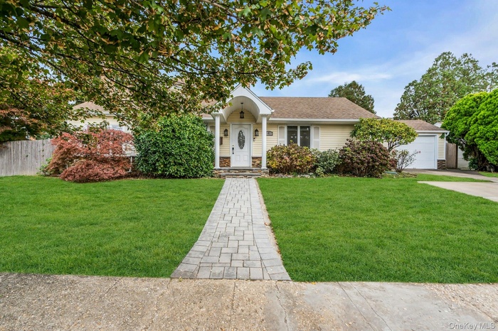 View of front of property with stone siding, a shingled roof, and a garage